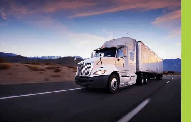 A white semi truck driving down the road.