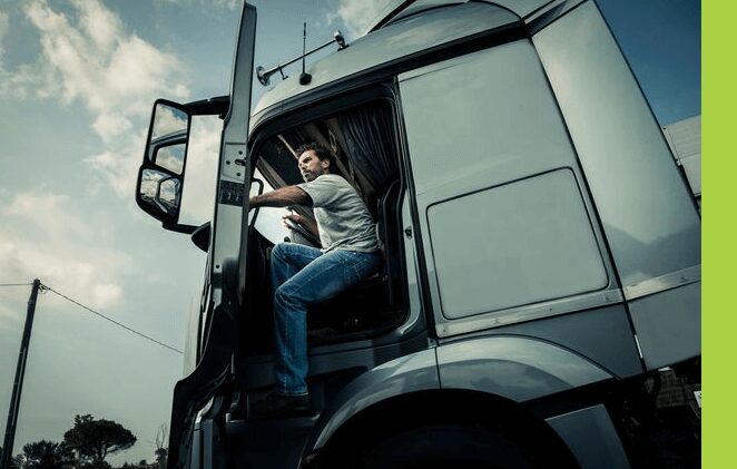 A man sitting in the drivers seat of a truck.